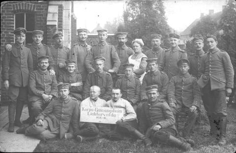 Een groep Duitse soldaten tijdens WO-1 met een dame in hun midden